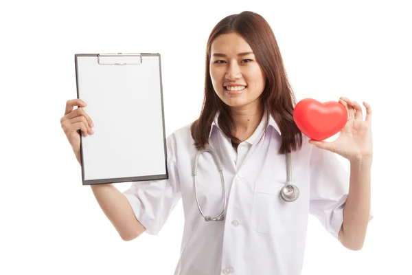 Joven asiática médico con corazón rojo y portapapeles en blanco . — Foto de Stock