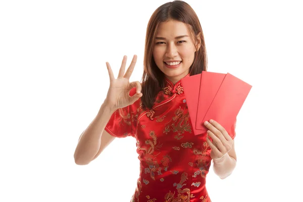 Asian girl in chinese cheongsam dress show OK with red envelope. — Stock Photo, Image