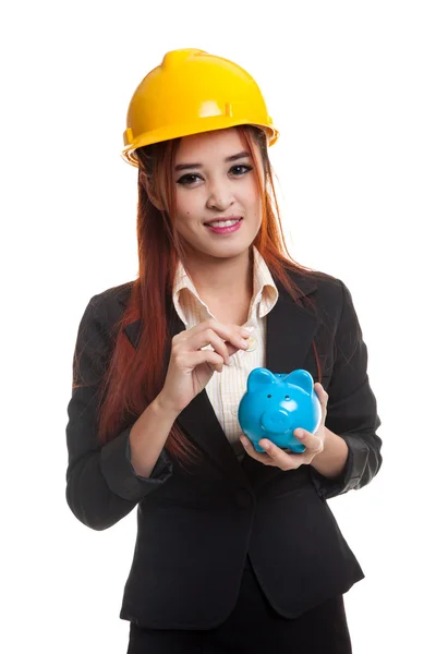 Aziatische ingenieur vrouw met een munt en piggy munt bank. — Stockfoto