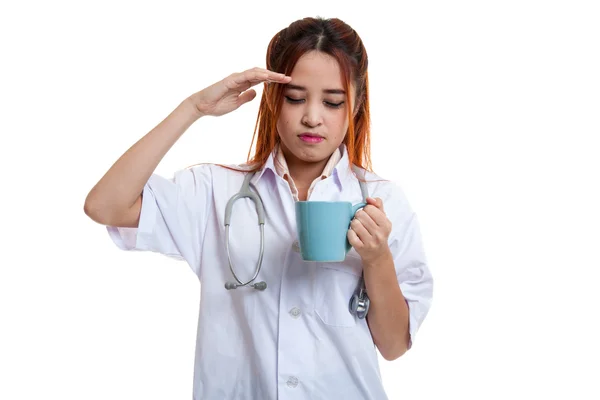 Asiatische junge Ärztin bekam Kopfschmerzen mit einer Tasse Kaffee. — Stockfoto