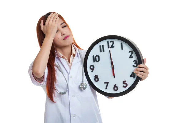 Jeune asiatique femme médecin maux de tête avec une horloge . — Photo