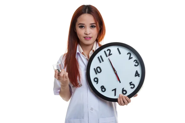 Joven asiática médico sonrisa con un reloj y pastillas en la mano . —  Fotos de Stock