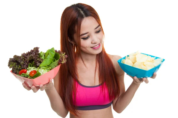 Schöne asiatische gesunde Mädchen Salat und Kartoffelchips. — Stockfoto