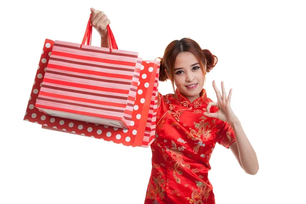 Asiatisk tjej i kinesiska cheongsam klänning med shopping väska. — Stockfoto