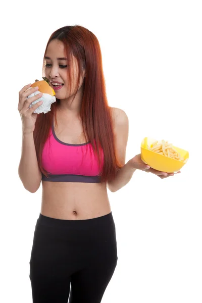 Schöne asiatische gesunde Mädchen mit Pommes und Hamburger. — Stockfoto