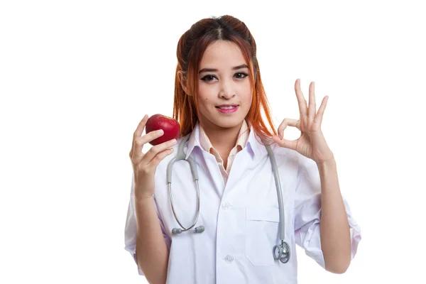 Junge asiatische weibliche Arzt zeigen ok mit Apfel. — Stockfoto