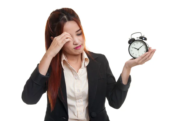 Sleepy young Asian business woman with a clock in the morning. Stock Image