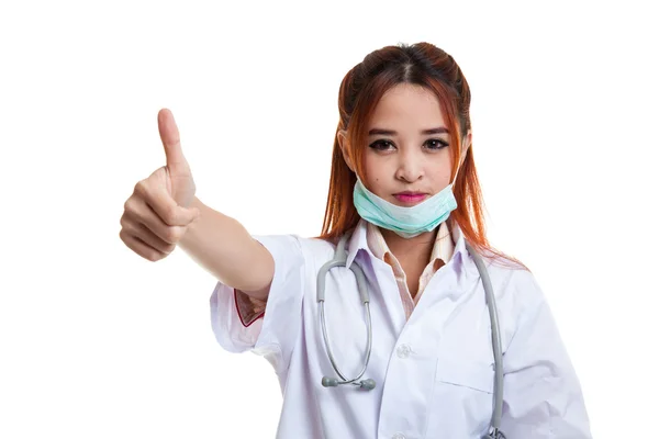 Mladá asijská ženský lékař vytáhnout masku a ukazují palec. — Stock fotografie