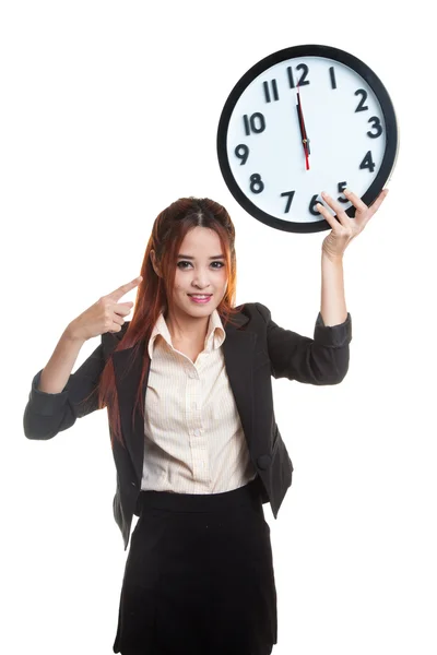 Giovane donna d'affari asiatica punta a un orologio . Foto Stock Royalty Free