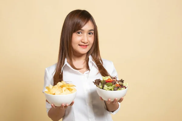 年轻的亚洲女人 有薯片和米色背景的沙拉 — 图库照片