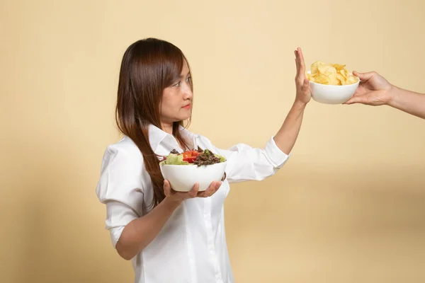 Junge Asiatin Mit Salat Sagt Nein Kartoffelchips Auf Beigem Hintergrund — Stockfoto