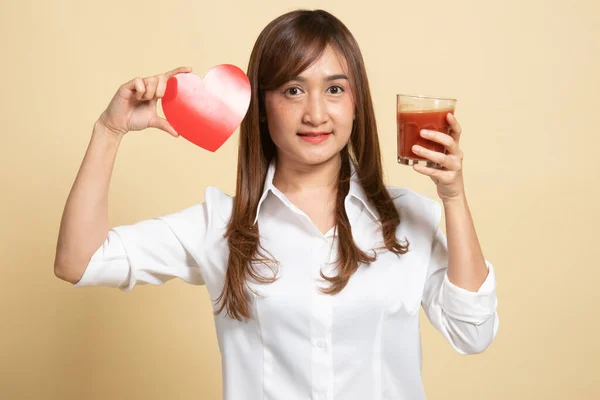 有番茄汁和红心的年轻亚洲女人的米色背景 — 图库照片