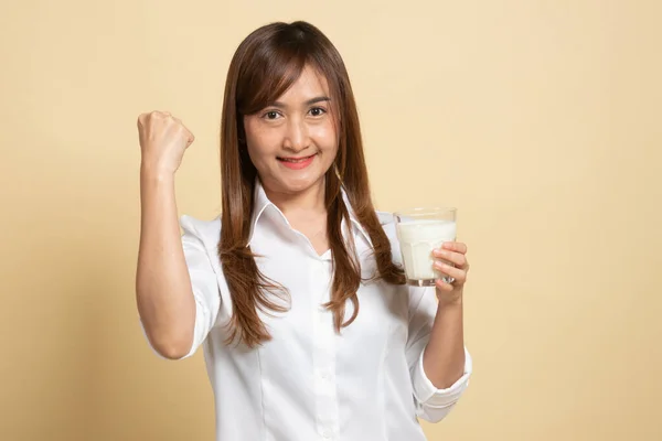 健康的亚洲女人在米色背景下喝一杯牛奶 — 图库照片