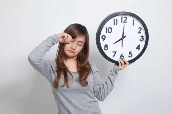 带有时钟的白色背景上早上睡眼惺忪的年轻亚洲女子 — 图库照片