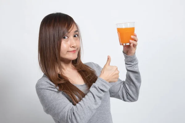 年轻的亚洲女人竖起大拇指在白色背景上喝桔子汁 — 图库照片