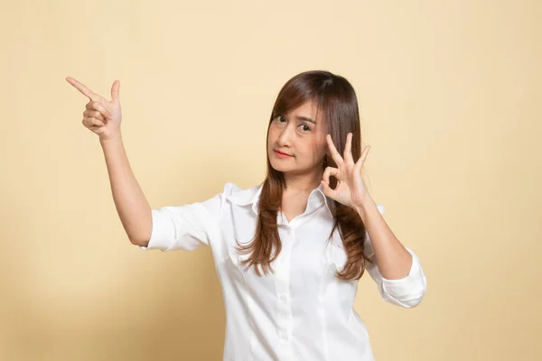 Junge Asiatin Zeigt Auf Beigen Hintergrund — Stockfoto