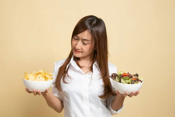 年轻的亚洲女人 有薯片和米色背景的沙拉 — 图库照片