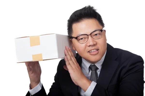 Asiático empresario es curioso lo que dentro de una caja y sonriendo — Foto de Stock