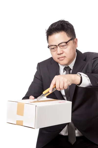Азиатский бизнесмен открывает коробку режущим ножом — стоковое фото