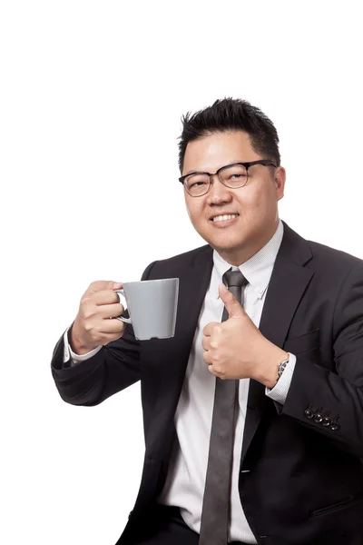 Asian business man holding a mug of coffee and thumbs up — Stock Photo, Image