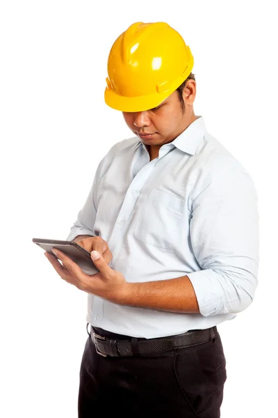 Asiatischer Ingenieur mit gelbem Hut schaut auf sein Tablet — Stockfoto