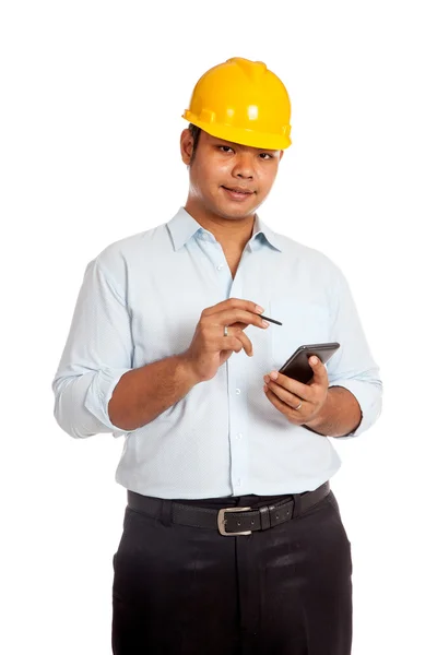 Азиатский инженер держит в руках телефон и ручку. — стоковое фото