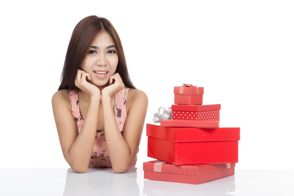 Beautiful Asian woman chin on hands with many gift box