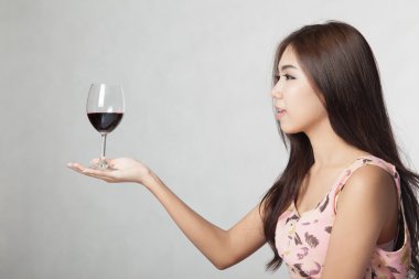 güzel Asyalı kadın kırmızı şarap palm elinde tut