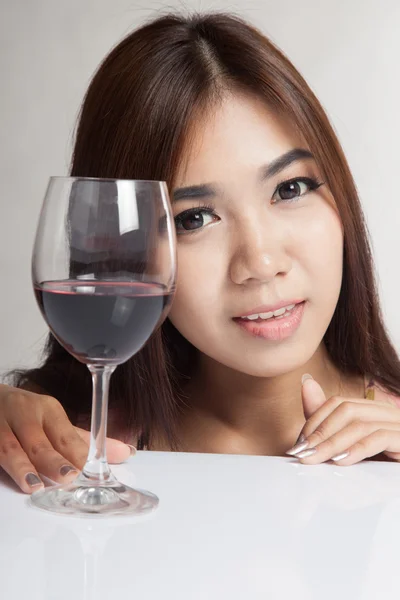 Beautiful Asian woman with red wine on white table — Stock Photo, Image
