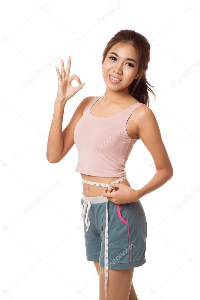 Asian slim girl with measuring tape show OK sign