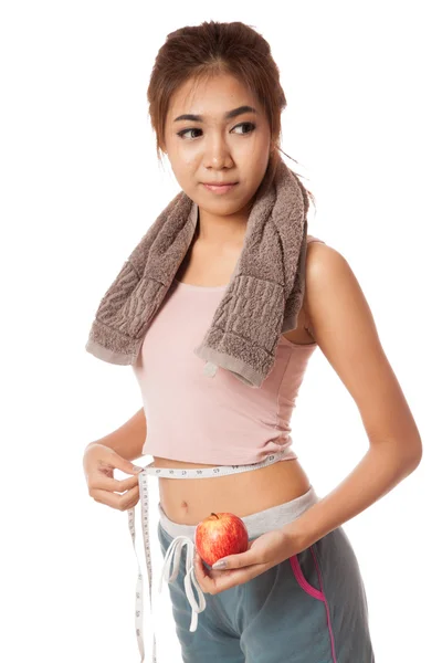 Азиатская здоровая девушка с яблоком, измеряющим ее талию — стоковое фото
