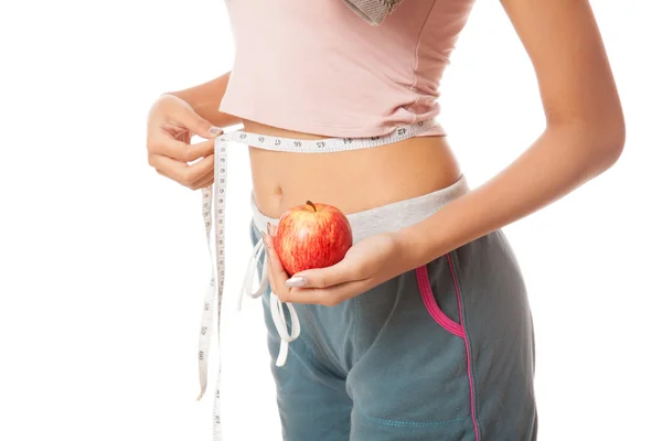 Талия азиатской здоровой девушки с измерительной лентой и яблоком — стоковое фото