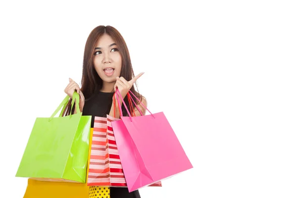 Emocionado mujer asiática apuntan a espacio vacío con bolsas de compras — Foto de Stock