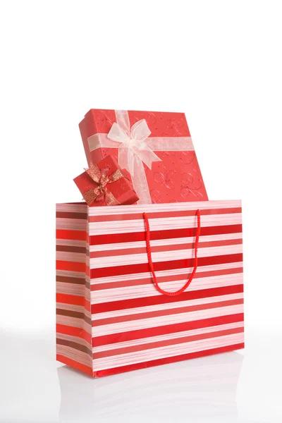 Röd presentförpackning i röda shopping väska — Stockfoto