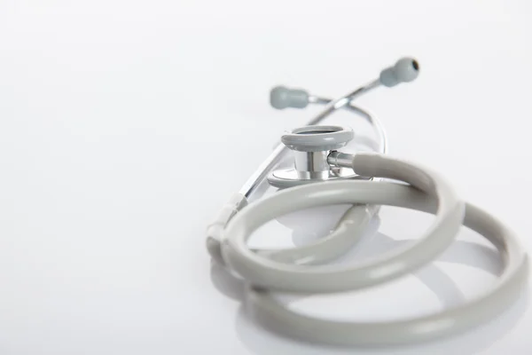 Beyaz parlak tabloda gri stetoskop — Stok fotoğraf