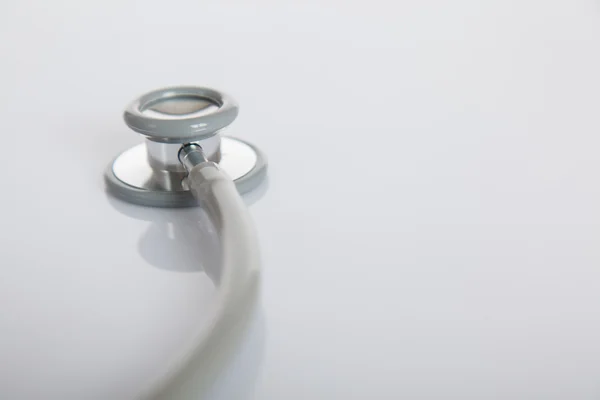 Beyaz parlak tabloda gri stetoskop — Stok fotoğraf