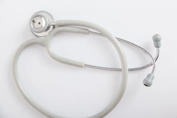 Gray stethoscope on white glossy table — Stock Photo, Image