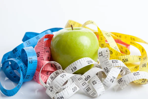 Colorful measuring tapes with green apple — Stock Photo, Image