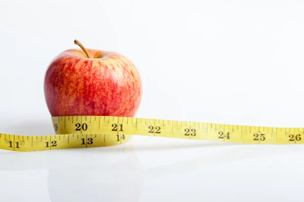 Yellow measuring tape with red apple — Stock Photo, Image