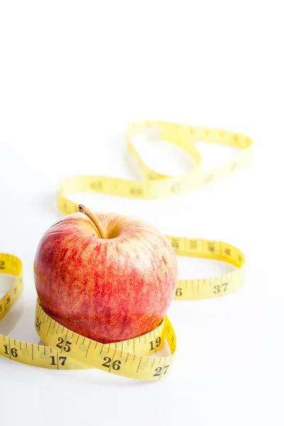 Yellow measuring tape with red apple — Stock Photo, Image