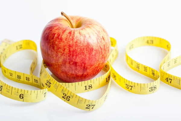 Yellow measuring tape with red apple — Stock Photo, Image