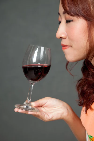 Asian girl close her eyes and smell aroma of red wine — Stock Photo, Image