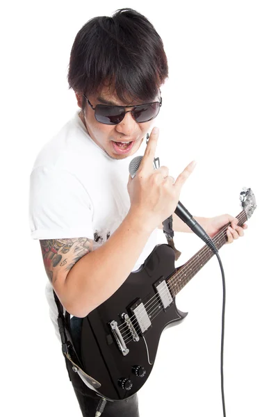 El rockero asiático toca la guitarra y canta con el cartel de rock — Foto de Stock