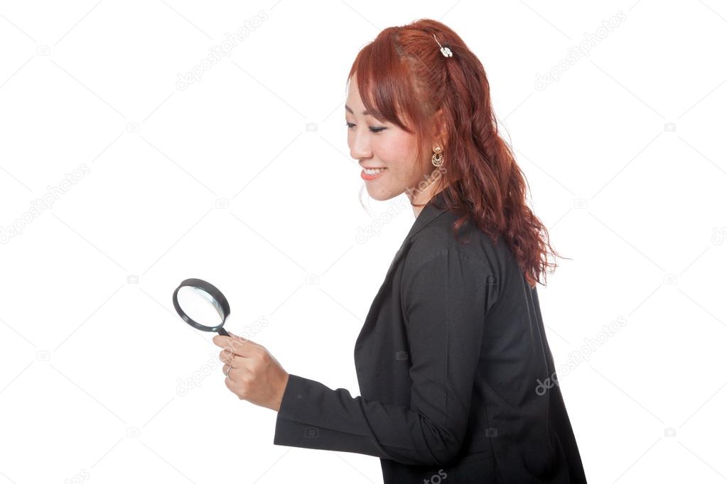 Asian office girl use magnifying glass looking down