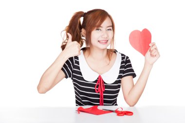 Asyalı kız sırıtmak başparmak ile kalp şekli kağıt