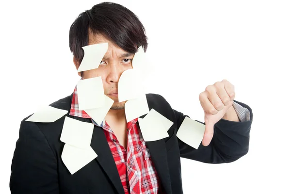 Asian office man covered in blank notes with his thumbs down — Stock Photo, Image