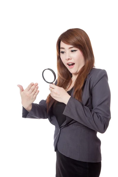Азиатская бизнесвумен удивлена использованием увеличительного стекла наблюдая за рукой — стоковое фото