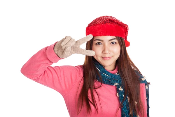 Азиатская девушка в красной рождественской шляпе показывает знак победы — стоковое фото