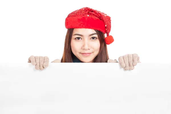 Asian girl with red christmas hat peeking from behind blank bann — Stock Photo, Image