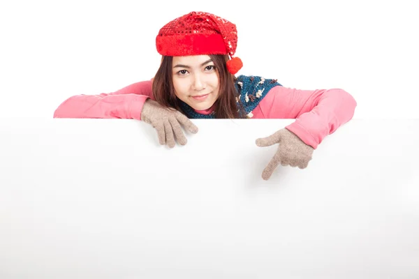 Asian girl with red christmas hat behind blank banner  point dow — Stock Photo, Image